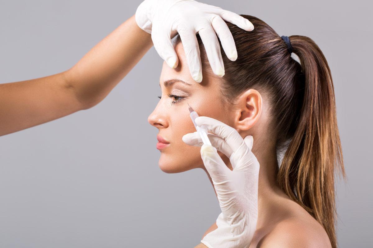 Young woman receiving botox injection.